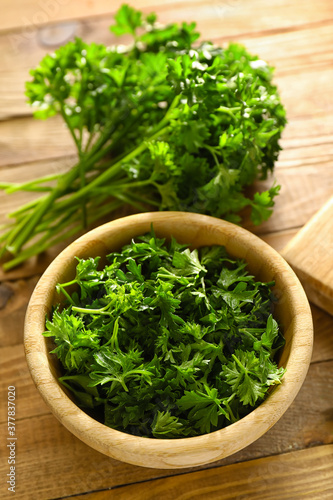 Fresh parsley in bowl on wooden background