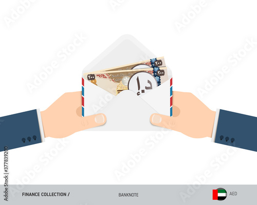 200 United Arab Emirates Dirham Banknotes in envelope hold in hand. Flat style opened white envelope with cash. Salary payout or corruption concept.