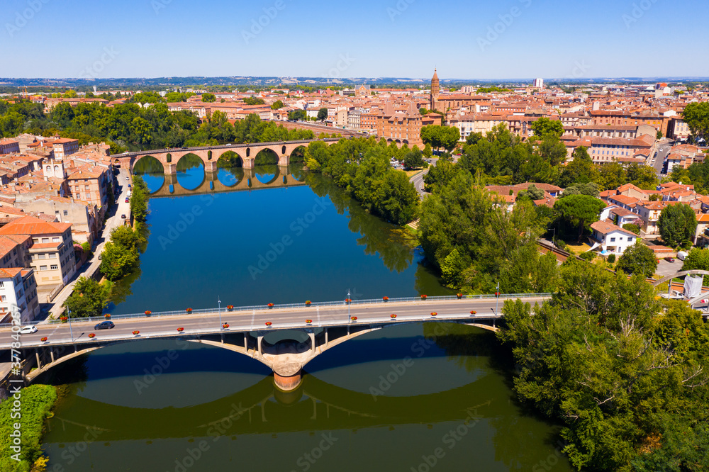 Obraz premium Picturesque view from drone of summer cityscape of Montauban with arched Old Bridge over river Tarn in summer day, Occitanie, France
