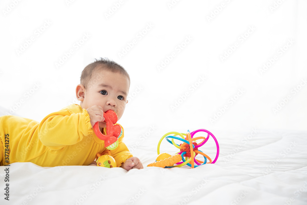Happy excited infant baby girl crawling and playing toy on the bed in the morning. Being a good child. Happy excited infant baby girl crawling and playing toy on the bed in the morning. Being a good child.