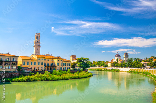 Verona cityscape with buildings on bank of Adige river, San Giorgio in Braida Roman Catholic church and Duomo di Verona bell tower Campanile, historical city centre, blue sky, Veneto Region, Italy photo