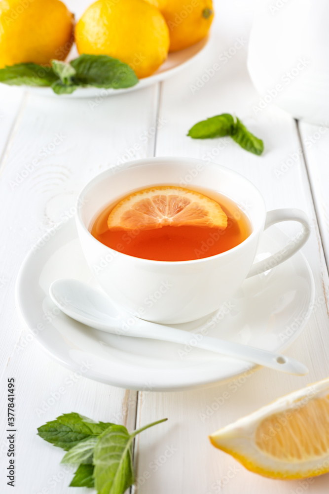 Vitamin, healthy tea with lemon and mint on a white wooden table. Alternative medicine concept. Vitamin, healthy tea with lemon and mint on a white wooden table. Alternative medicine concept.