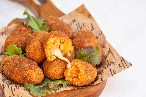Rice balls stuffed with mozzarella cheese and deep fried. Close up. Copy space. photo