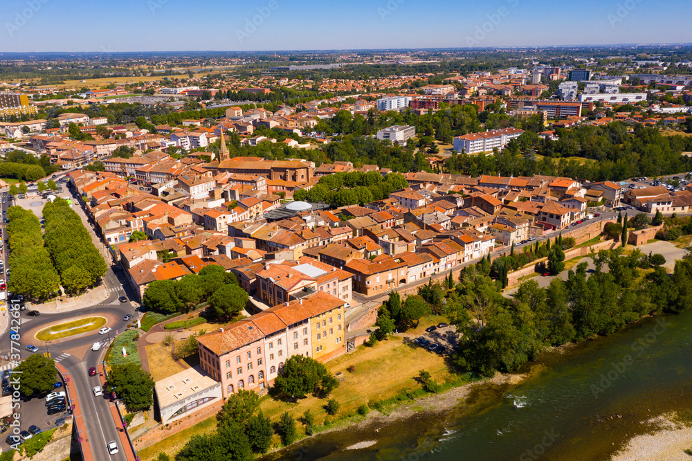 Flight over the city Muret and Garonne river on summer day. France