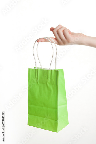 woman's hand holding shopping bag on white background