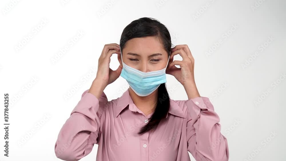 Asian young woman wearing protective mask in in slow motion, Protection versus viruses and infection, Isolated on white background Asian young woman wearing protective mask in in slow motion, Protection versus viruses and infection, Isolated on white background