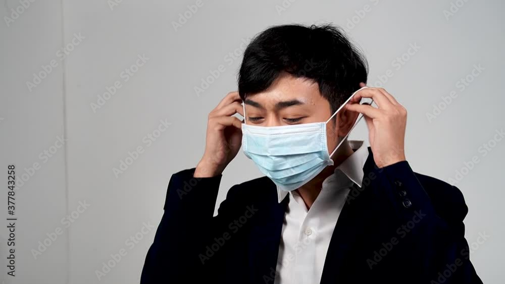 Asian young man wearing protective mask in slow motion, Protection versus viruses and infection, Isolated on white background Asian young man wearing protective mask in slow motion, Protection versus viruses and infection, Isolated on white background