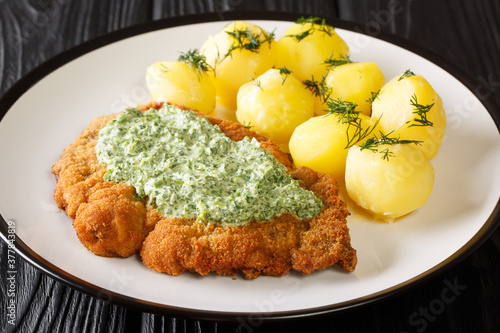 фотографія Breaded schnitzel with boiled potatoes and Frankfurt green sauce close-up in a plate on the table