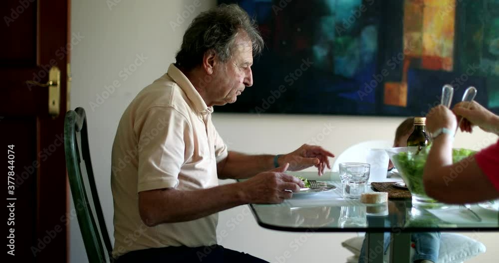Family at meal table, grandfather with baby grandchild eating lunch Family at meal table, grandfather with baby grandchild eating lunch