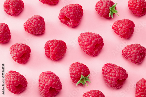 ripe raspberries on pink background. top view. flat lay photo