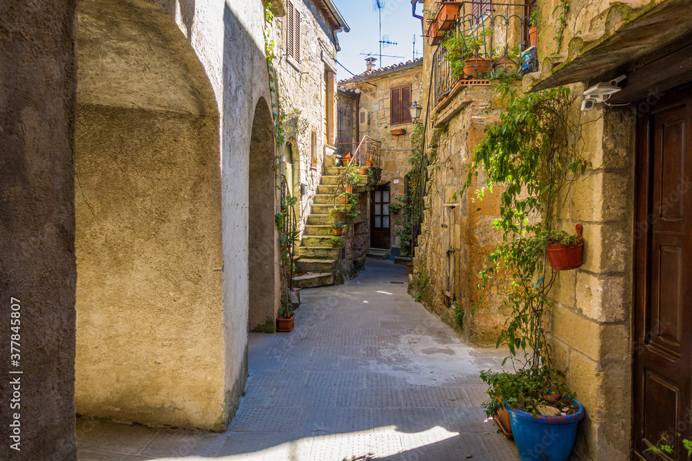 Fototapeta Pitigliano, Tuscany perched on tuff cliff, Old Town and alleys. Splendid town in the Tufo Area, in the heart of Tuscan Maremma, Pitigliano perched on tuff cliff one of most beautiful villages in Italy