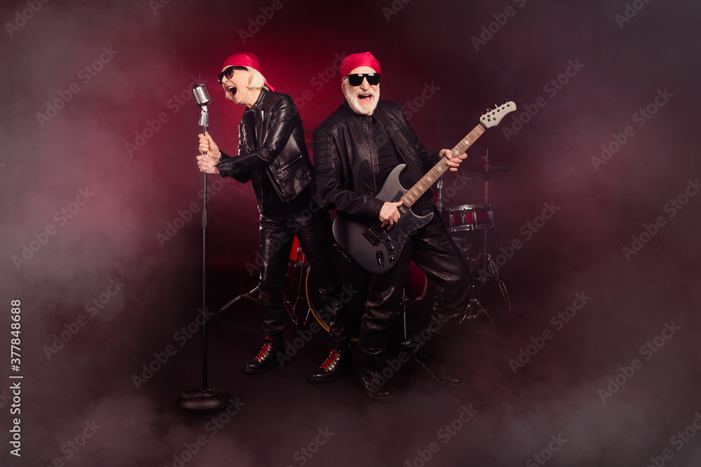 Photo of two aged lady man popular old rock group perform concert play solo guitar sing legend song farewell show career end wear trendy rocker leather outfit isolated black color background