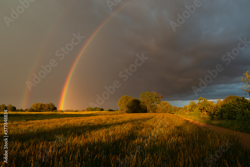 A double rainbow against the background of stormy clouds