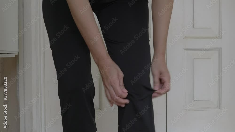 Knee pain. Woman hands rubbing her knee cap, hurting and in pain