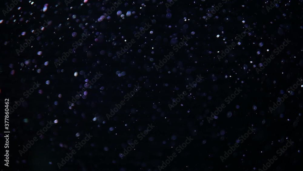 Abstract fast crystal macro Bubbles of air moving and floating isolated on Black Background in aquarim under water. Close up and copy space. Like a winter