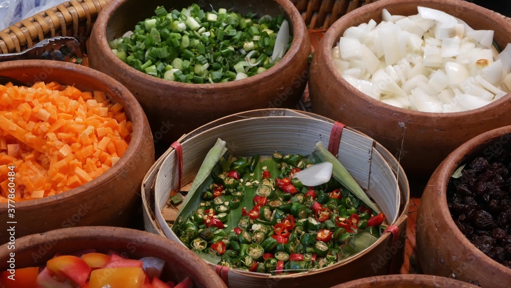 Top view of selection of various platters with delicious asian food and spices on a street market stall in Bangkok, Thailand.