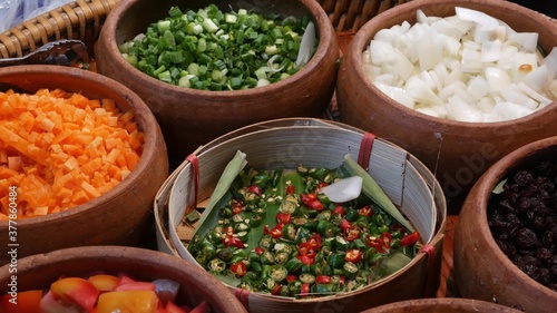 Top view of selection of various platters with delicious asian food and spices on a street market stall in Bangkok, Thailand.