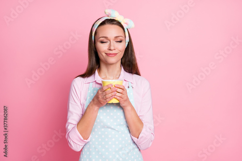 Portrait of positive cheerful girl hold caffeine beverage mug smell aroma wear shirt isolated over pastel color background