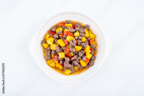 Diced beef with bell pepper on a dish of home cooking on white background