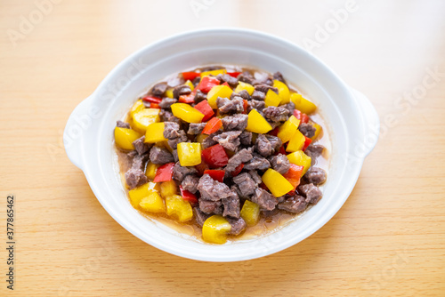 A dish of diced beef with colored pepper