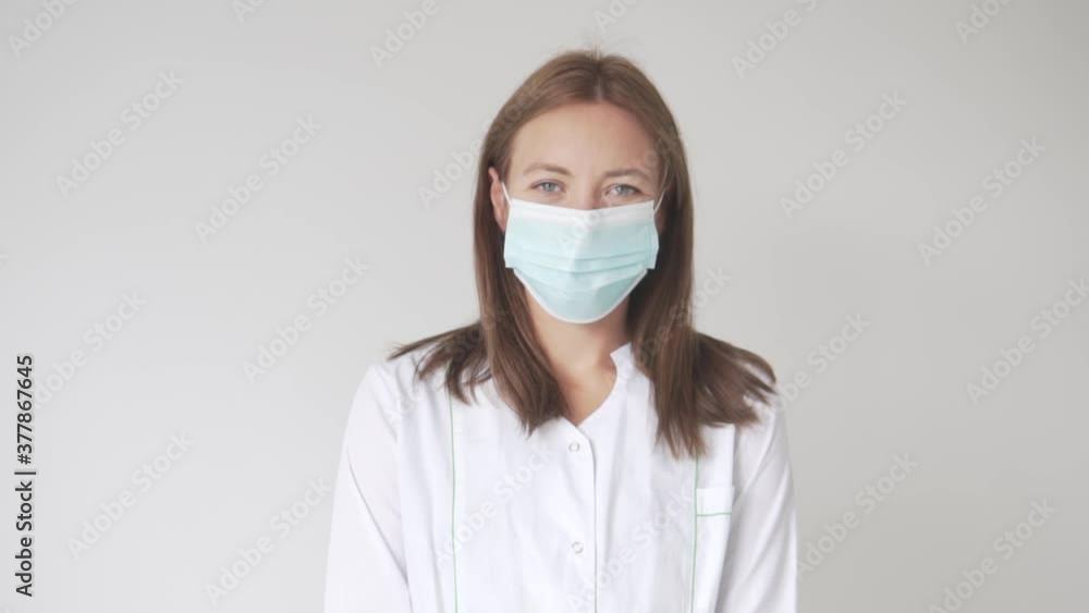 Close-up of a beautiful female doctor with a protective mask on her face. Close-up of a beautiful female doctor with a protective mask on her face.