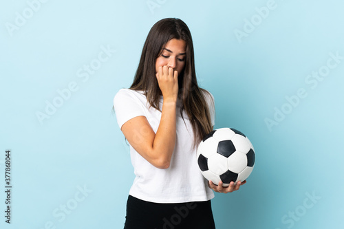 Young football player brazilian girl isolated on blue background having doubts © luismolinero