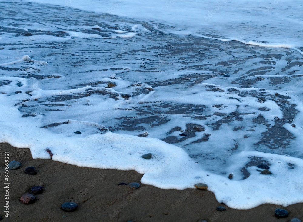 Fototapeta premium foam wave on the sea sand of the beach