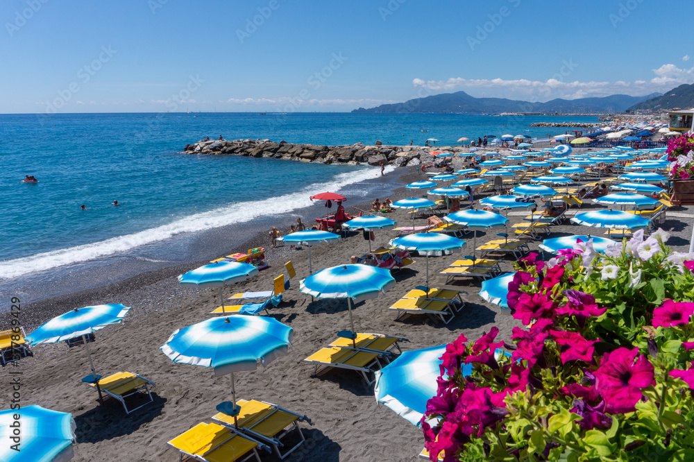 beach view with umbrellas and deck chairs in summer, Liguria