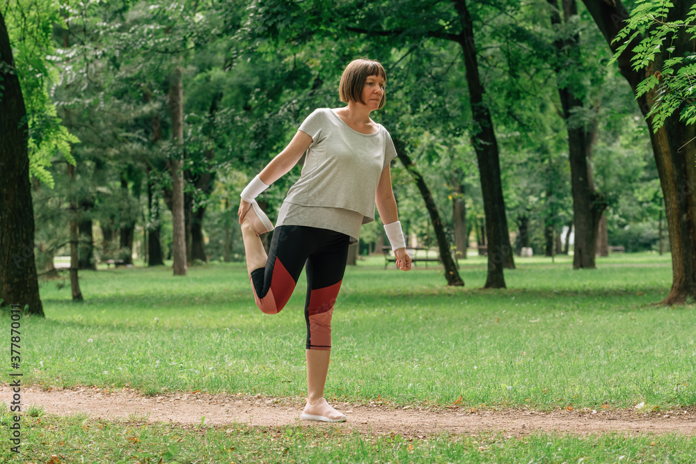 Female jogger stretching muscles and warming up for running exercise in park Female jogger stretching muscles and warming up for running exercise in park
