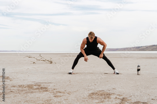 Image of young athletic sportsman doing exercise while working out