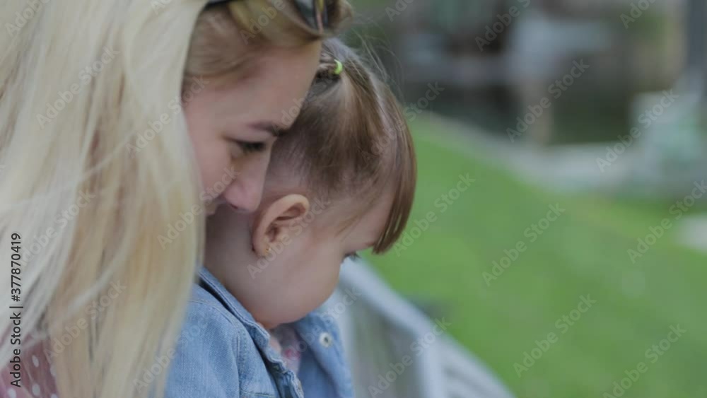 Happy young mother with little daughter in her arms in the park. Happy young mother with little daughter in her arms in the park.