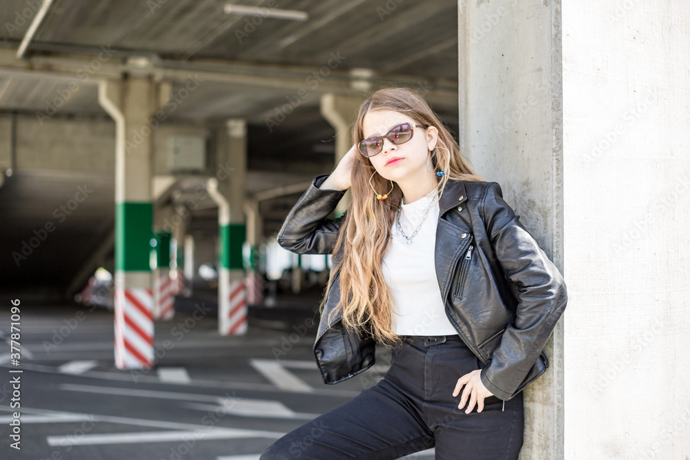 young schoolgirl with bright pink makeup in black leather jacket posing in the parking lot young schoolgirl with bright pink makeup in black leather jacket posing in the parking lot