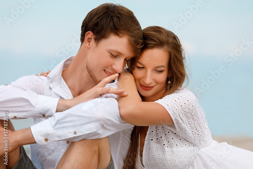 Portrait of a cute couple of young lovers resting on the beach