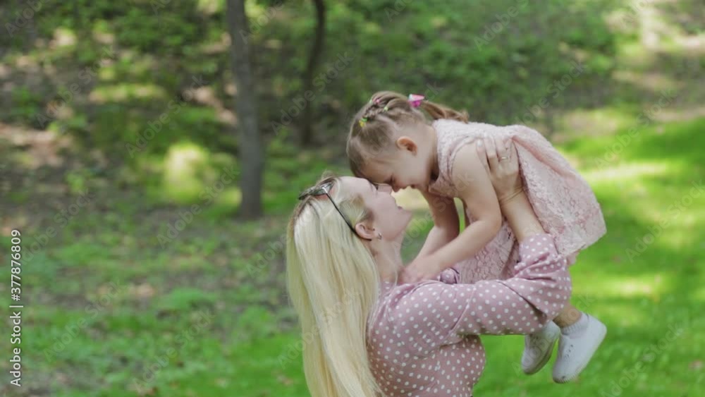 Young mother and little daughter are having fun in the park in sunny weather. Young mother and little daughter are having fun in the park in sunny weather.