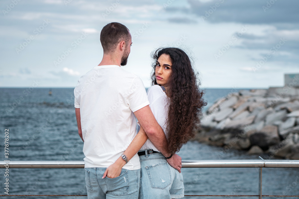 Young couple at the beach being sweet and in love. Boyfriend and girlfriend outdoors photoshoot. Romantic scene of a millennial couple in matching outfits Young couple at the beach being sweet and in love. Boyfriend and girlfriend outdoors photoshoot. Romantic scene of a millennial couple in matching outfits