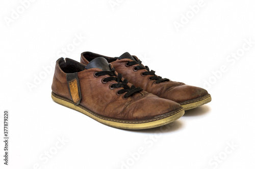 Old dirty brown leather shoes on an isolated white background. Concept, second hand, hard work, walking, worn out pair of lace-up low shoes. High quality photo © Denis_Markashanskiy