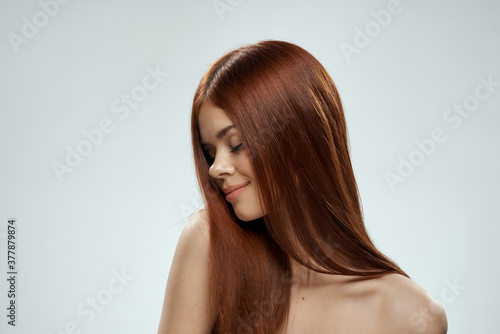 Woman with beautiful long hair care nude shoulders cosmetics cropped view light background