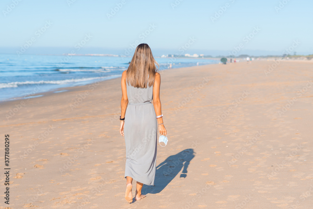 Young woman walk on an empty Beach . No people on the beach because of the coronavirus Young woman walk on an empty Beach . No people on the beach because of the coronavirus