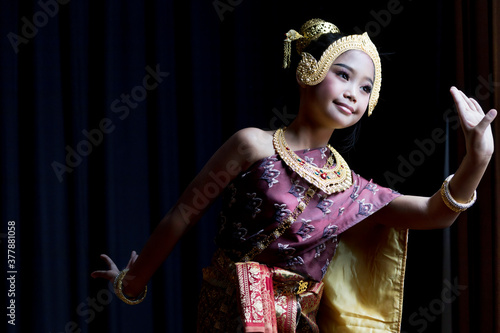 A cute Asian schoolgirl dressed in Thai costumes and performed dances in traditional Thai dances.