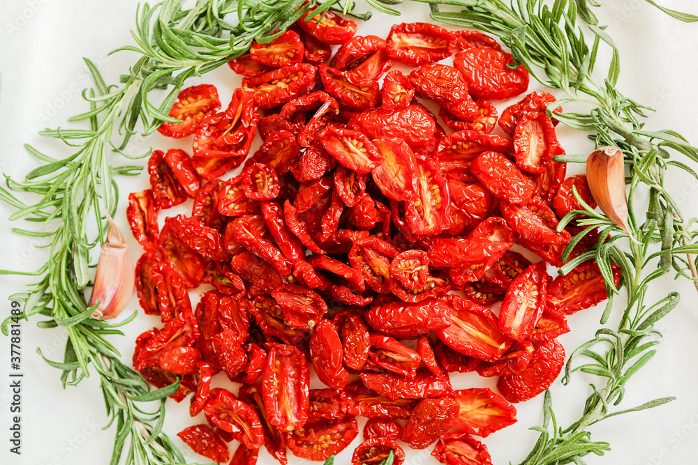 Homemade sun-Dried tomatoes with fresh rosemary and garlic cloves. The view from the top. Print for kitchen Homemade sun-Dried tomatoes with fresh rosemary and garlic cloves. The view from the top. Print for kitchen
