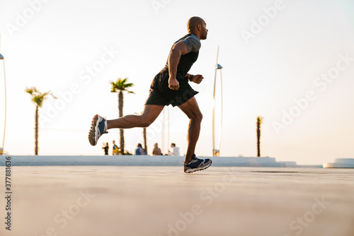 Handsome strong sportsman running on a street © Drobot Dean
