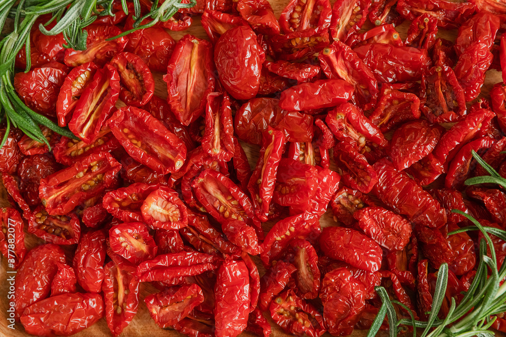 Homemade sun-Dried tomatoes with fresh rosemary. The view from the top. Print for kitchen Homemade sun-Dried tomatoes with fresh rosemary. The view from the top. Print for kitchen