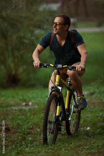 Fototapeta Naklejka Na Ścianę i Meble -  Young man cycling on bicycle in the public park