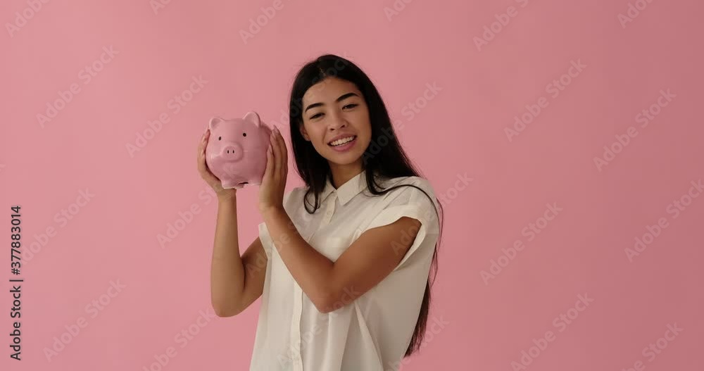 Joyful woman holding piggy bank with lots of money Joyful woman holding piggy bank with lots of money