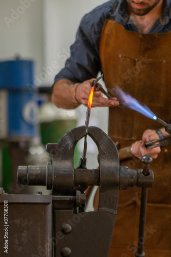 A blacksmith work on metal