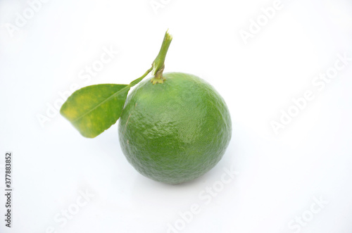 the ripe green orange fruit with leaves isolated on white background.