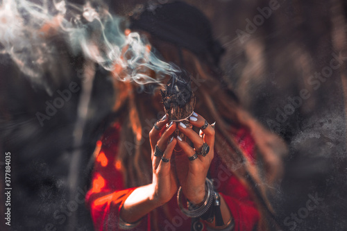 close up of woman hands with shamanic fire outdoors photo