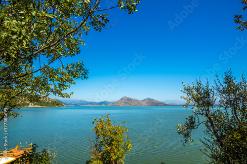 View of Lake Skadar from the mountains from behind the trees, framed photo