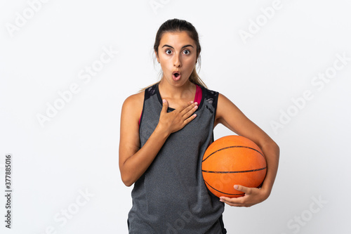 Young hispanic woman playing basketball over isolated white background surprised and shocked while looking right
