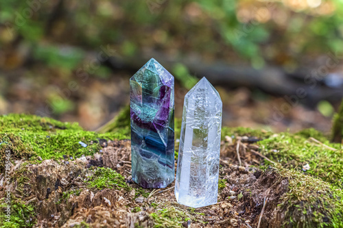 Gemstones fluorite, quartz crystal. Magic rock for mystic ritual, witchcraft Wiccan and spiritual practice on stump in forest. Meditation reiki, spiritual healing consept. Out focus, bakclight